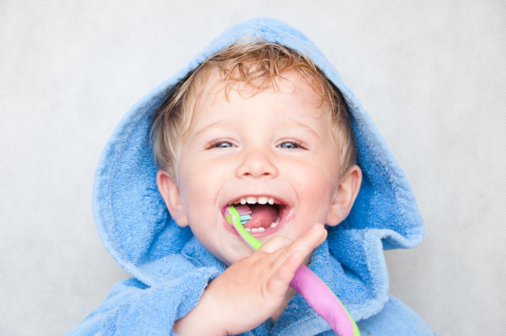 child smiling with toothbrush | family dentist jonesboro