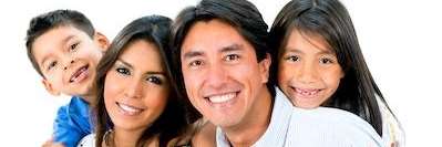 A smiling family posing on a white background | dentist Jonesboro