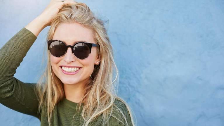A woman with sunglasses smiling | Jonesboro dentist