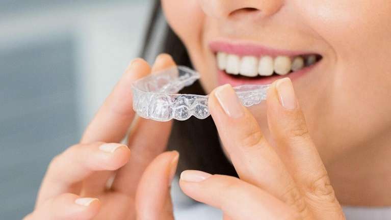 woman putting in her Invisalign tray