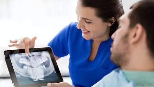 A dentist showing her patient his dental x-rays