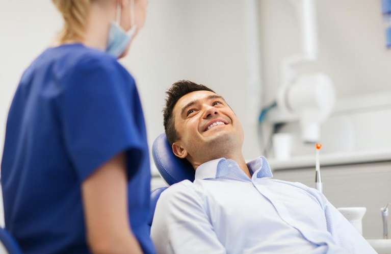 A smiling man talking to his dentist
