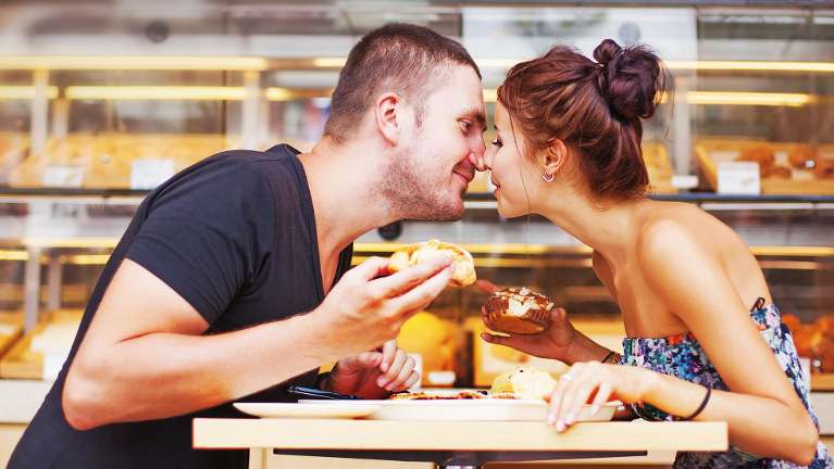 Couple kissing with snacks