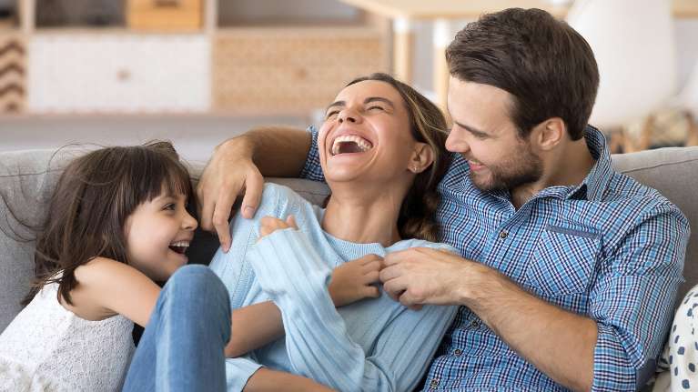 A family laughing on the couch