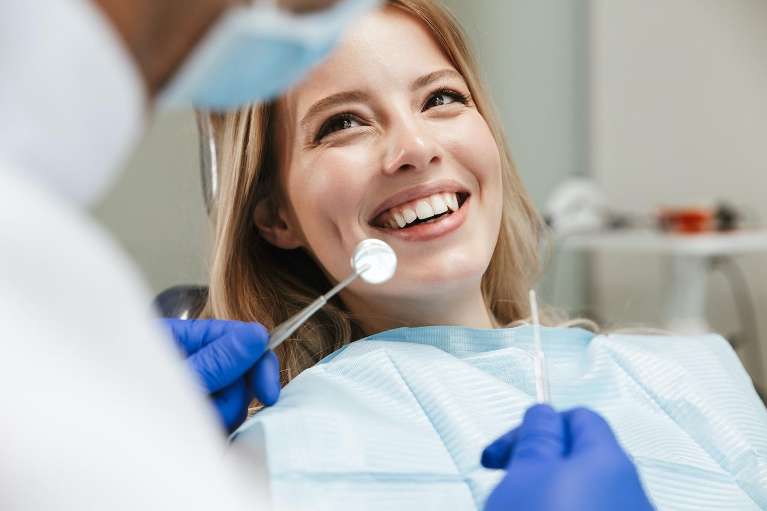 A smiling woman getting a dental exam in Jonesboro