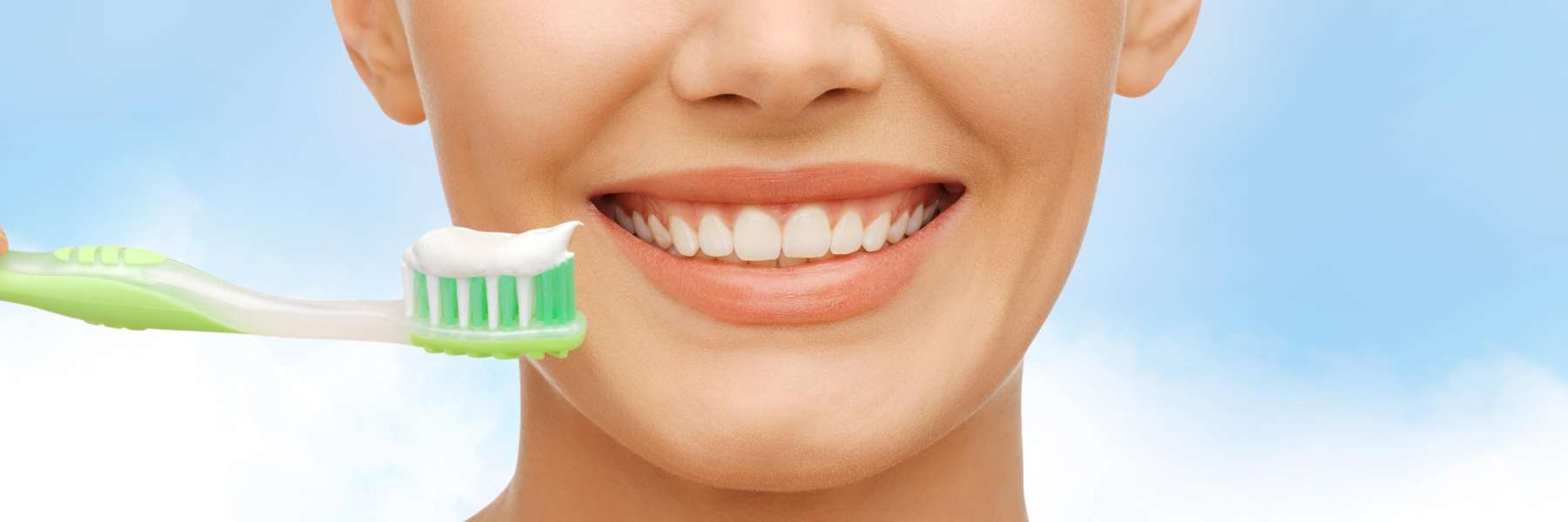 A woman smiling about to brush her teeth | Family Dentist Jonesboro
